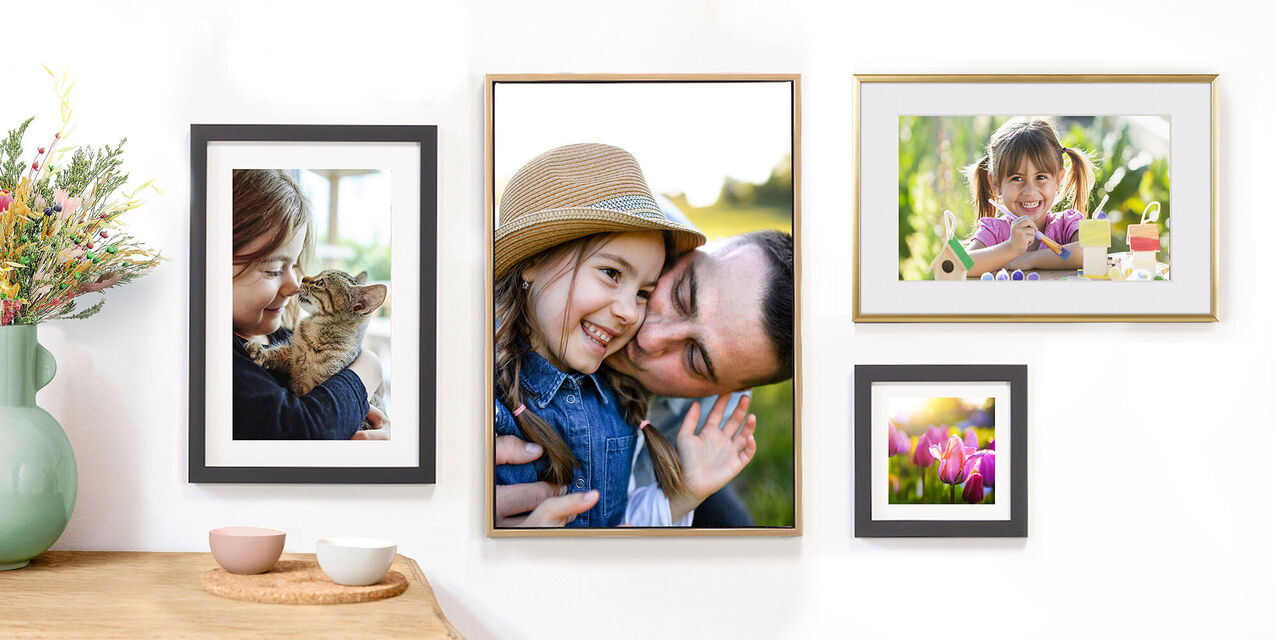 Flere familiebilder på en bildevegg i stue