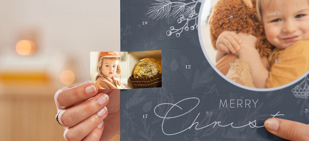 En person holder en CEWE fotokalender med kjærlige bilder og jentedesign.